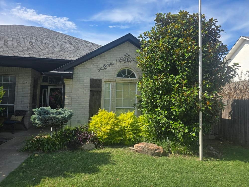 Front view of a charming house with a landscaped garden and colorful shrubbery.