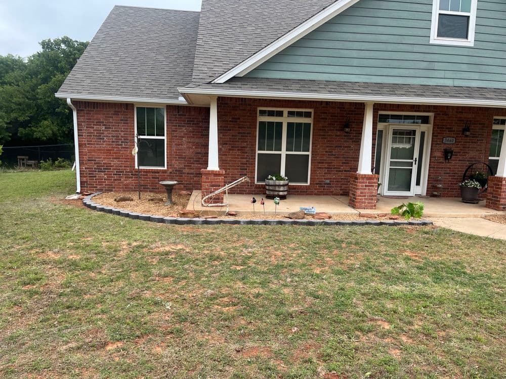 Home exterior featuring brick walls, garden edging, and vibrant landscaping.